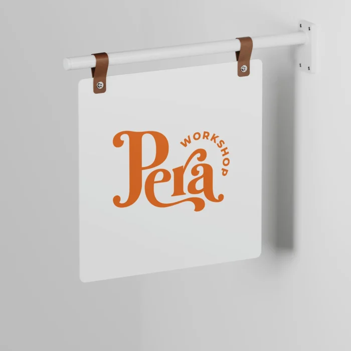 beyaz duvarda asılı bir sallanan tabela. üzerinde pera logosu var.