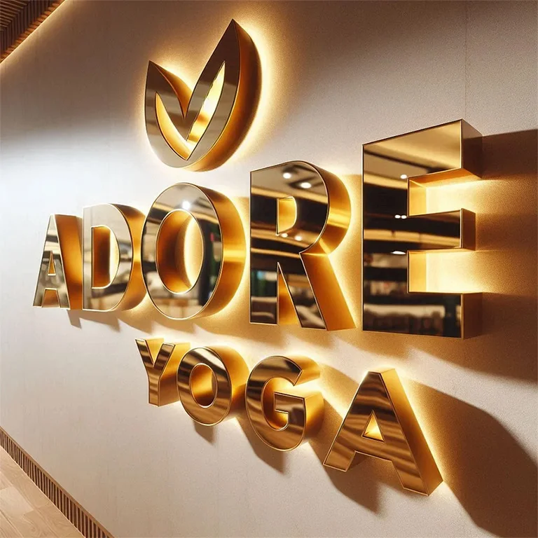 Duvara monte edilmiş altın renkli ışıklı yoga stüdyosu tabelası.
