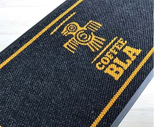 Kafe girişine yerleştirilmiş özel logolu ve sloganlı karşılama paspası.