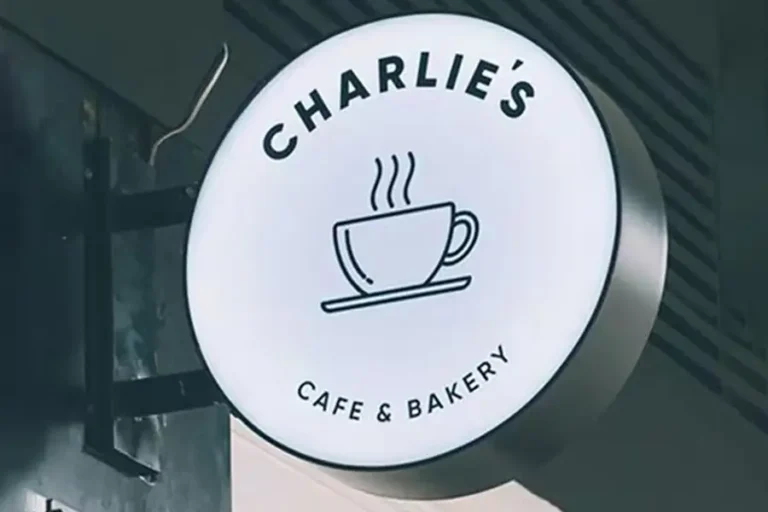 Kafe dış duvarına monte edilmiş çift taraflı ışıklı yuvarlak fener tabela örneği.